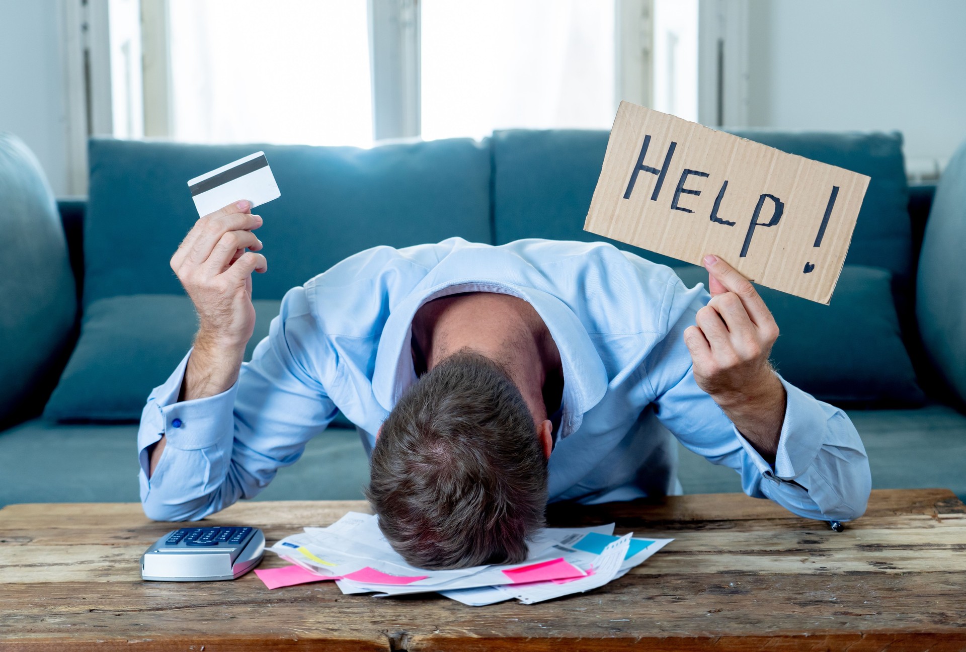 Besorgte und verzweifelte Geschäftsleute, die um Hilfe bei der Tilgung von Schulden und Kreditberechnung Rechnungen Steueraufwendungen und Buchhaltung Finanzen sitzen auf der Couch in der Bezahlung von Rechnungen und Finanzprobleme Konzept.